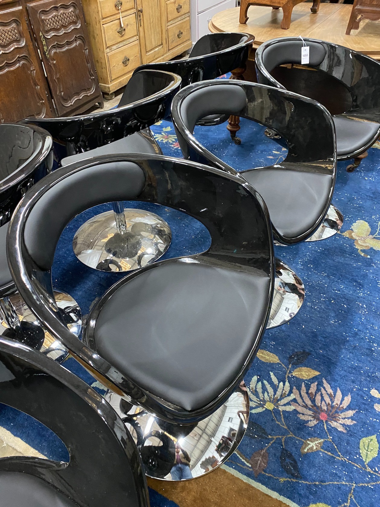 A set of eight black phenolic dining chairs with telescopic bases, width 63cm